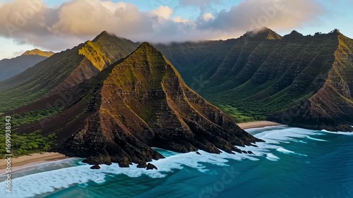 Dramatic coastal mountains meet turquoise ocean waves under a golden sunset sky.