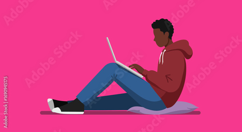 Casual young person using a laptop on a cushion against a vibrant background. Ideal for themes of online education, remote work, or digital lifestyle.