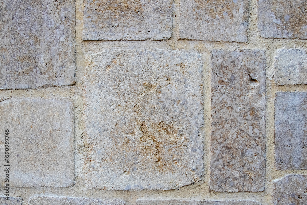 Fototapeta premium Stone wall texture with large rectangular gray beige blocks for architectural design and construction projects