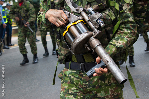 Soldier with grenade launcher, Military holding grenade launcher, Armed forces carrying grenade launcher, Soldier equipped with grenade launcher. High quality photo