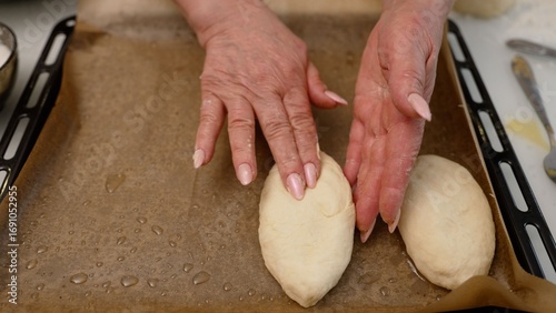 Baker arranging uncooked pies on baking sheet