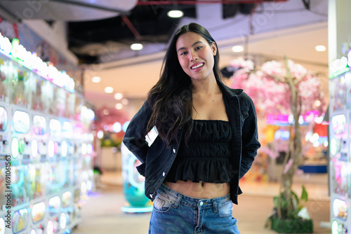 Happy young woman playing arcade video games indoors
