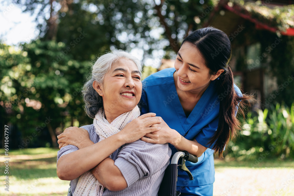 Fototapeta premium A woman in a wheelchair is being comforted by a woman in a blue uniform
