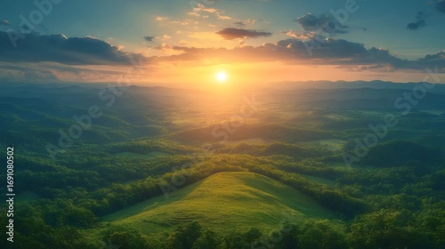 鮮やかな日の出が丘陵地の緑の木々の上空を照らす壮大なシーン