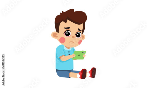 Sad young boy sitting on the floor and looking at a green tablet with a worried expression.