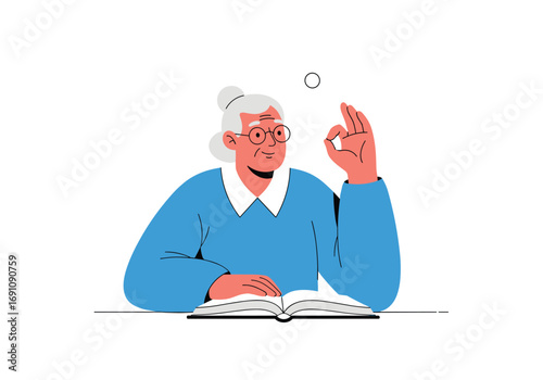 An elderly woman with gray hair wearing glasses sitting at a table with an open book