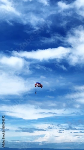 Two people fly on a parachute over a sky-blue sea on two domes towed by a boat. parasailing