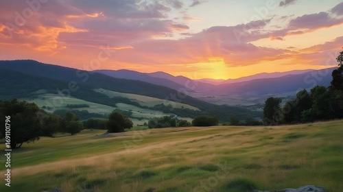 緑の丘陵とドラマチックな夕焼け空の美しい風景