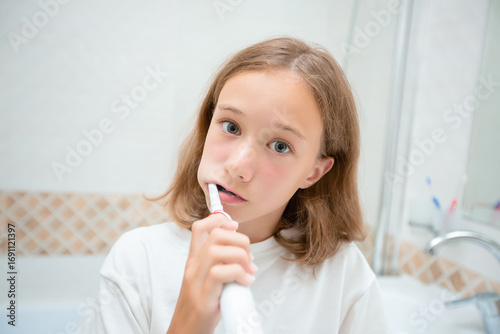 Dental hygiene. Happy little blonde girl brushing her teeth. Healthy concept