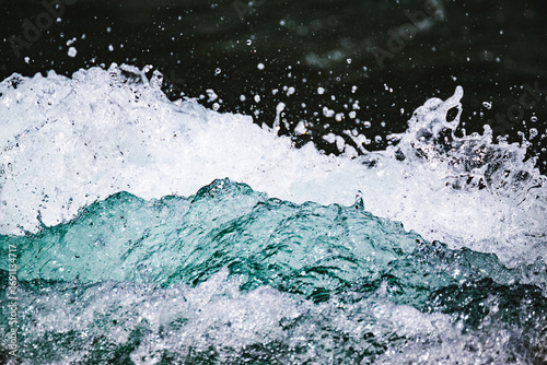 Closeup shot of water crashing up against a boulder