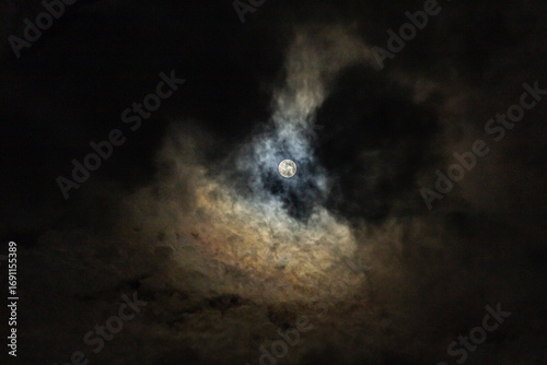 Full moon in the night sky with clouds, closeup of photo