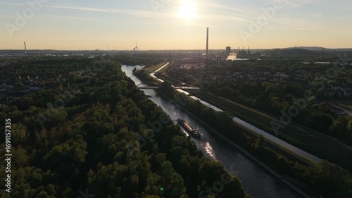 Transportschiff fährt auf einem Kanal in die untergehende Sonne 