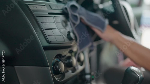 A man taking care of his car cleans the dashboard carefully.