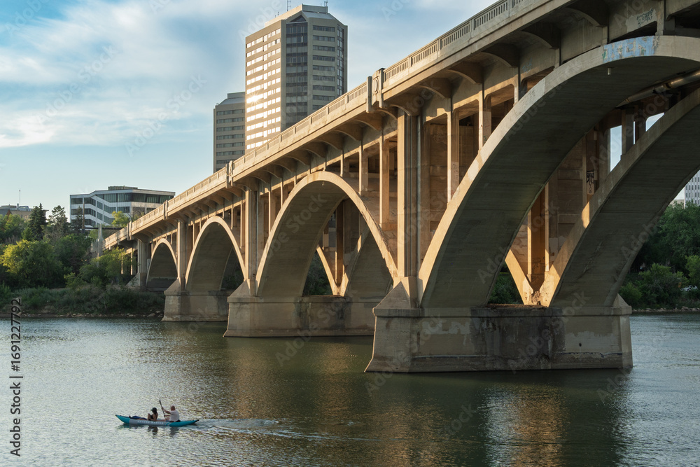 Naklejka premium Bridge spans a river with a boat in the water