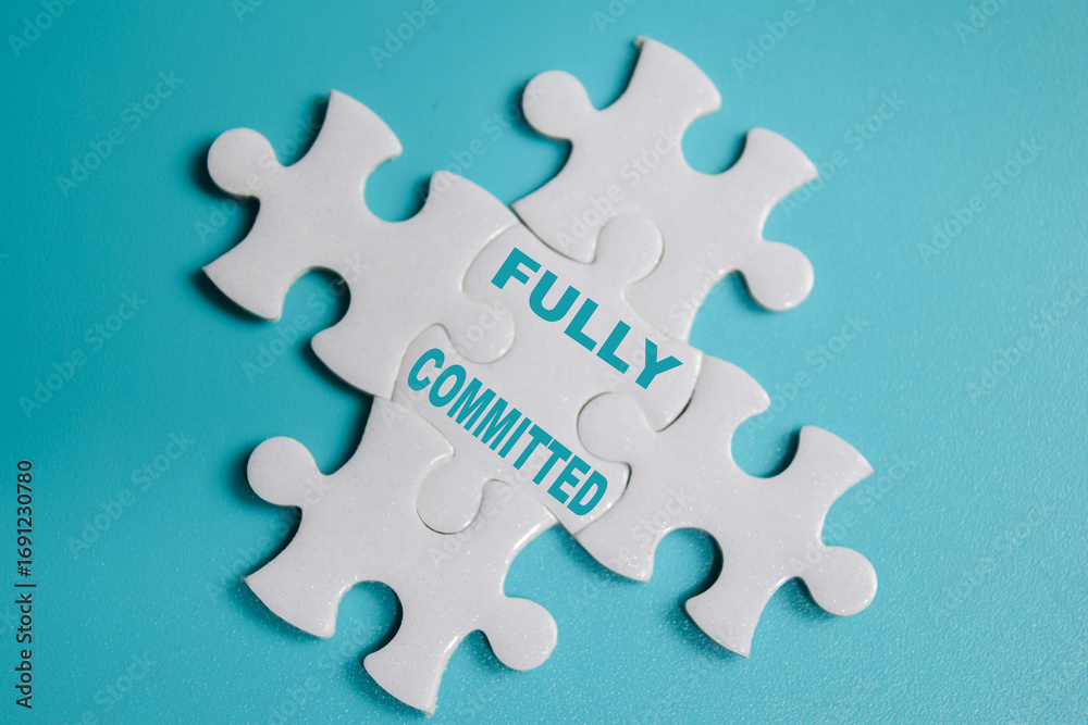 Fototapeta premium piece of jigsaw puzzle with word Fully committed. Business and finance concept