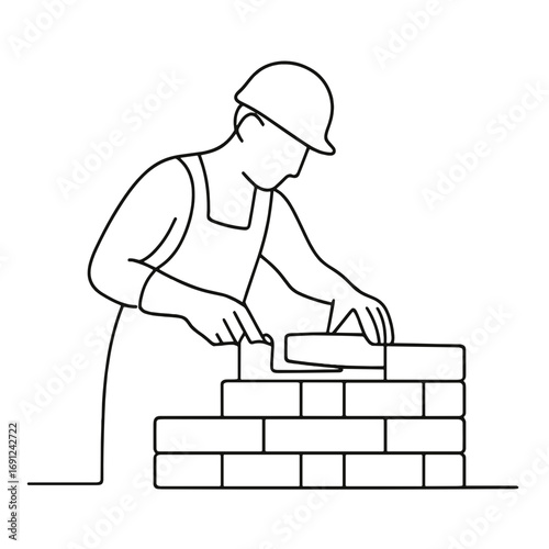 Construction worker laying bricks with trowel at building site  