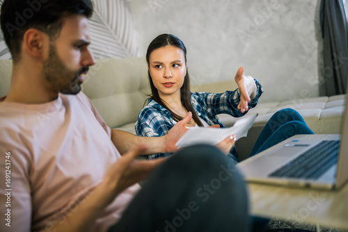 Stressed couple arguing over unpaid bills at home