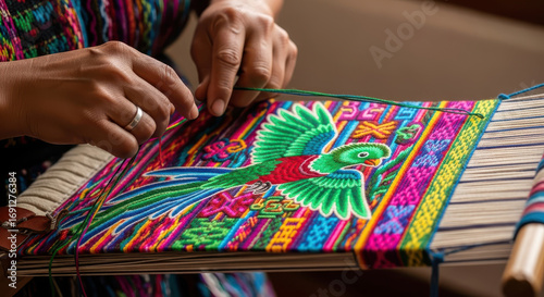 closeup of hands weaving textile with colorful parrot design or national quetzal bird. traditional craftsmanship and cultural art in process. textile, handmade crafts, guatemala cultural heritage