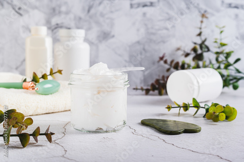 Beef tallow for skin care in a jar and massagers on the table