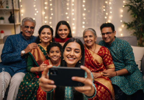 indian family taking selfie during ganesh chaturthi celebration. smiling faces in traditional attire with festive lights in background. hindu festival, cultural event. greeting card, poster.