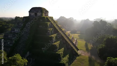 Ancient mayan pyramid temple overgrown with lush green vegetation, bathed in the warm morning sunlight, standing majestically amidst a dense jungle, a testament to a lost civilization