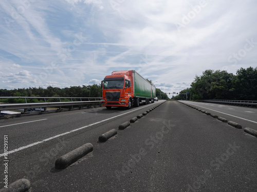 Wallpaper Mural Orange truck with green trailer on highway with concrete barriers and overcast sky Torontodigital.ca