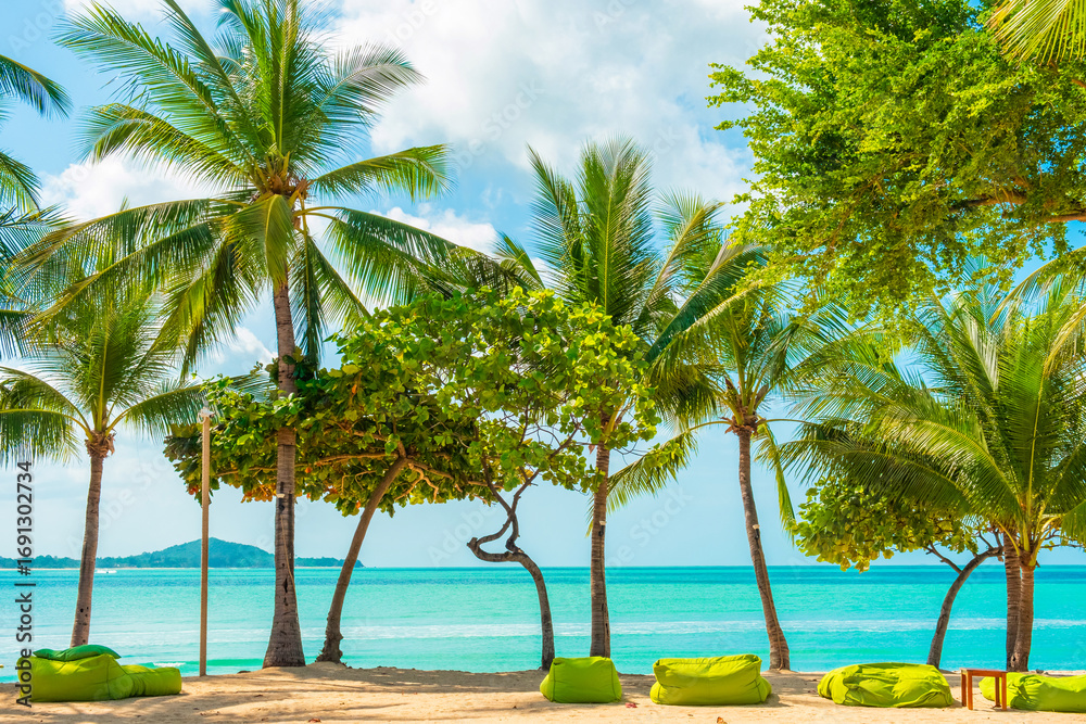 Obraz premium Tropical W beach on Koh Samui island with green bean bags, palm trees, golden sand and turquoise sea under sunny blue sky, Thailand. Eco tourism, beach resorts and tropical escape in Asia