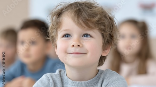 Focused Young Boy in Classroom Looking Up with Diverse Classmates in Background, Education Concept