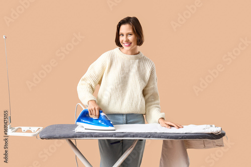 Young woman ironing clothes...