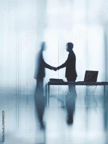 Two business people shaking hands in a modern office setting