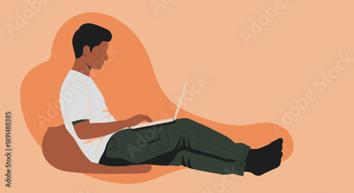 Young man relaxing at home, focused on his laptop. Ideal for concepts of remote work, online learning, casual lifestyle, or digital communication.