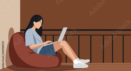 Woman comfortably working or studying on a laptop from home, sitting on a bean bag in a relaxed setting. Ideal for remote work, online learning, or digital lifestyle.