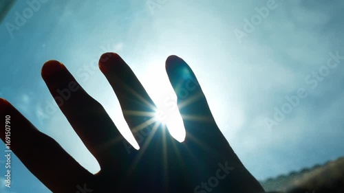 Reaching up to block the glaring sun reflects setting boundaries, managing exposure, and adapting to the environment. It highlights awareness, self-protection, and navigating obstacles.
