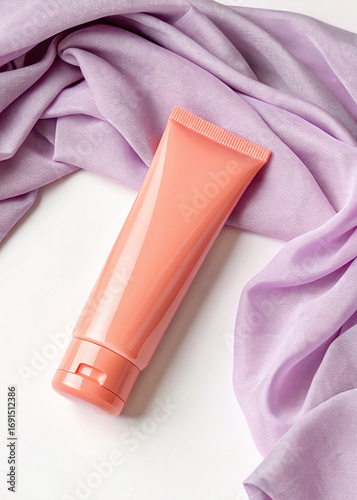 Coral Cosmetic Tube on Lilac Fabric with Soft Lighting and White Background mockup