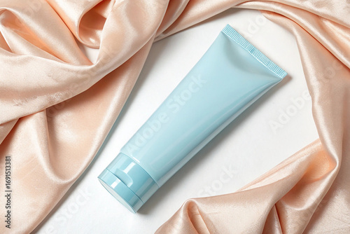 Light Blue Cosmetic Tube Framed by Peach Silk on White Background mockup