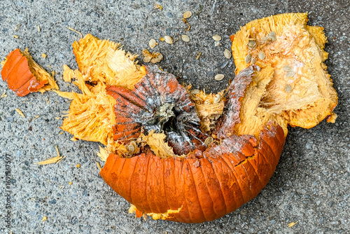 Destroyed Halloween pumpkin lies smashed on pavement