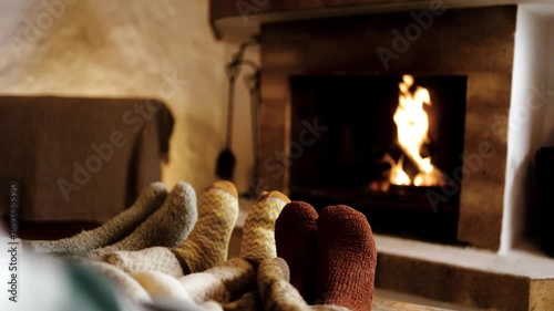 Feet in wool socks near fireplace in winter - Cozy christmas holiday home relaxation