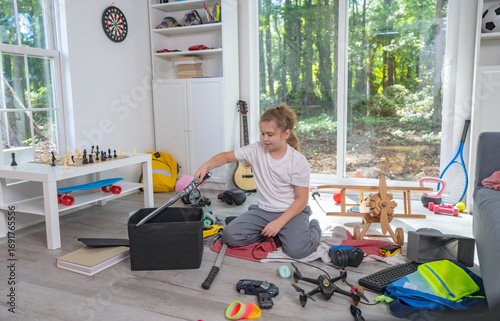 Foto Child cleaning toys in playroom