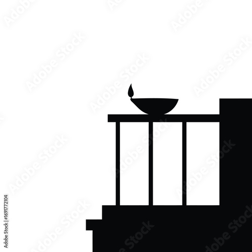 Black diya on balcony railing lamp flame