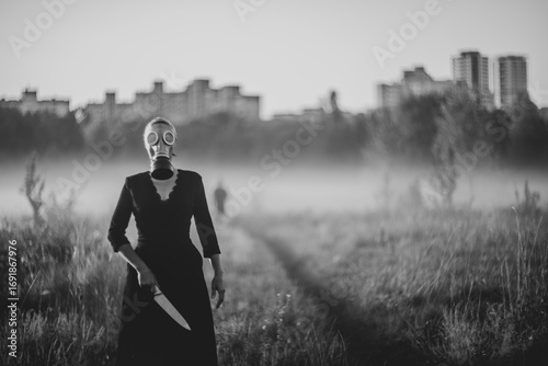  A mysterious masked woman holding knife in foggy field