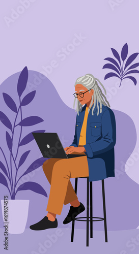 A focused senior woman with dreadlocks and glasses works on a laptop, embodying modern digital engagement and remote productivity for mature individuals.