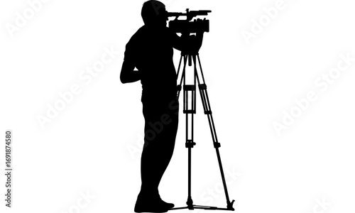 Silhouette of a cameraman using a professional video camera on a tripod.