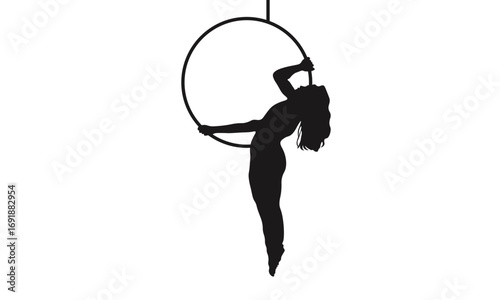 Silhouette of a woman performing aerial hoop acrobatics, hanging upside down.