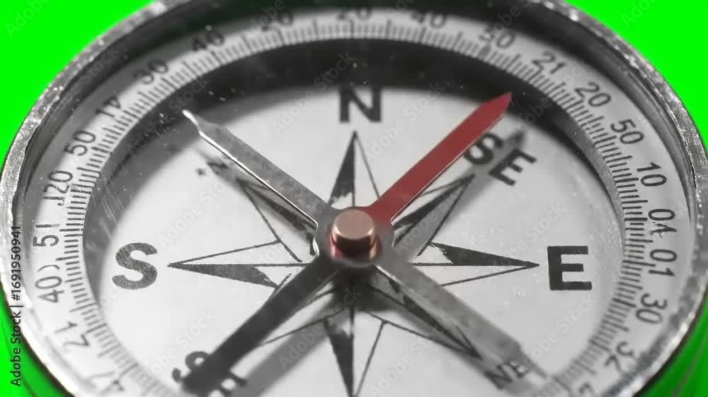 Close Up of Magnetic Compass Needle Spinning and Settling on Green Screen Background