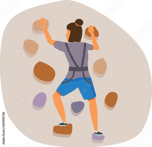 Woman practicing indoor rock climbing on an artificial climbing wall, enjoying a challenging and active lifestyle