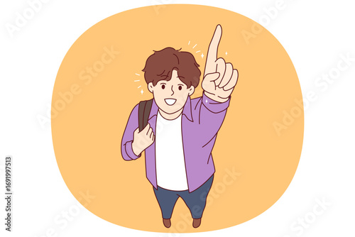Happy college student pointing finger up and smiling, holding backpack on shoulder. Male student rejoices at opportunity to study at university and gains knowledge to build successful career