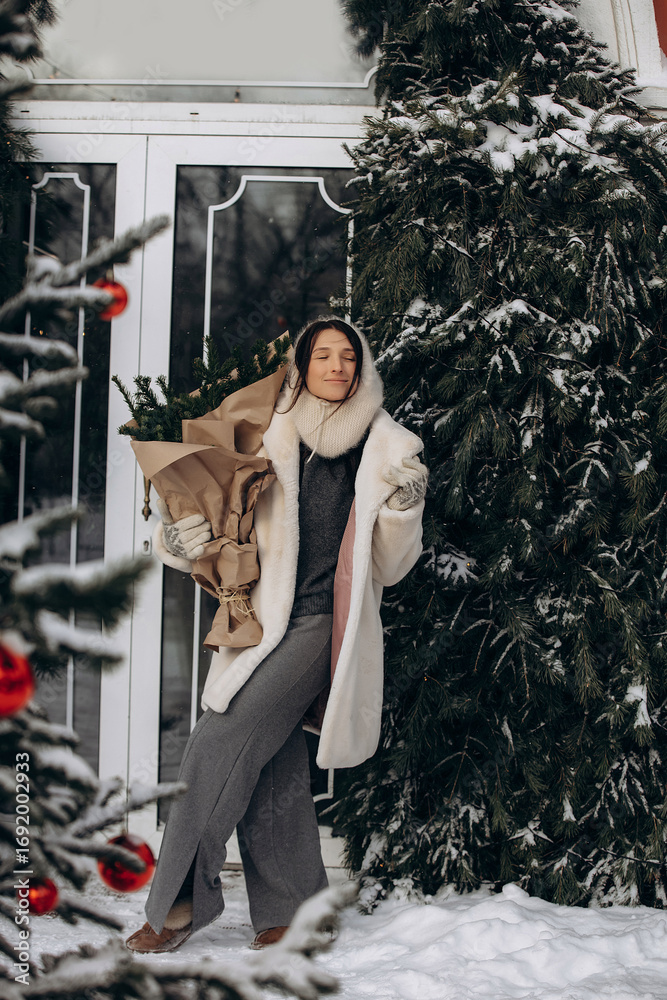 Obraz premium A woman walks along a city street on Christmas Eve in search of gifts and a good mood