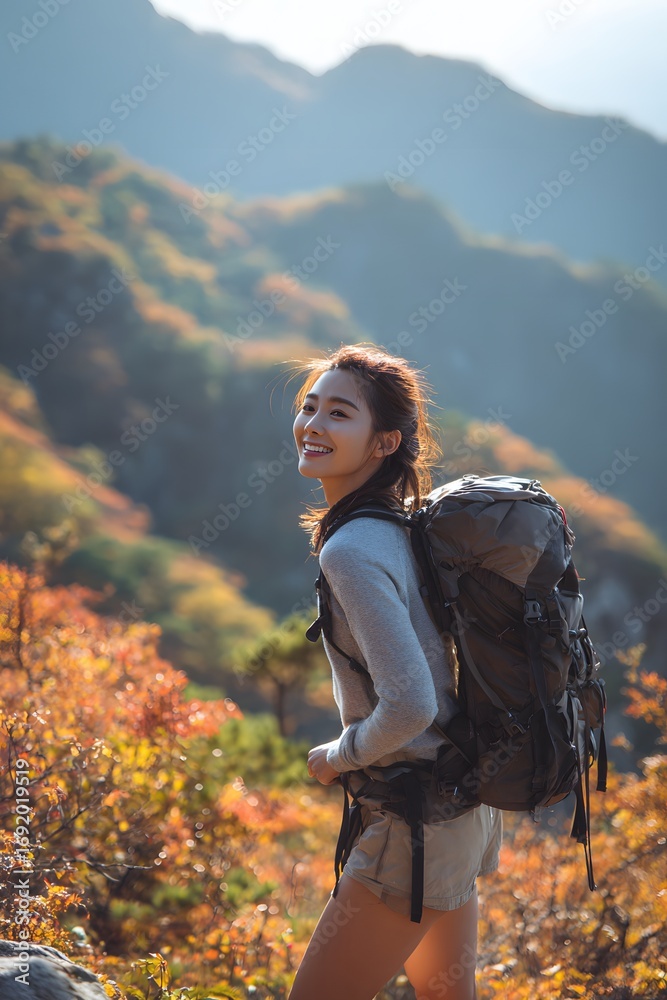 Naklejka premium Female backpacker hiking in autumn mountains
