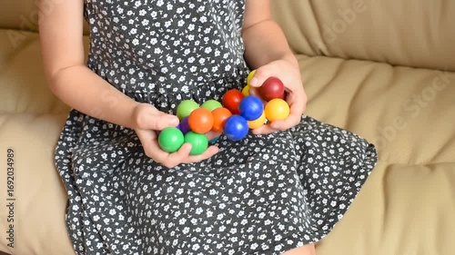 Closeup of children's hands with logic puzzle game with colorful balls