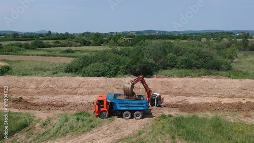 Excavator Loading Dump Truck on Construction Site